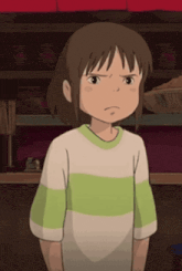 a girl in a green and white striped shirt is making a funny face