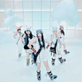a group of girls are dancing and one has a microphone on her shoulder that says ' nn ' on it