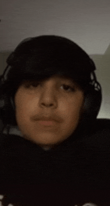 a young boy wearing headphones looks at the camera .