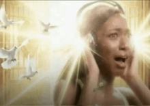 a woman wearing headphones is singing with birds flying around her .