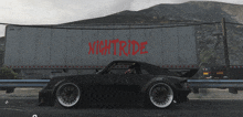 a black car is parked in front of a night ride trailer