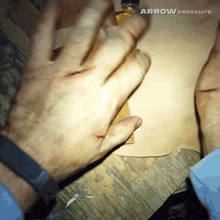 a person 's hand is on a piece of paper that says arrow presents on the bottom