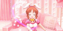 a girl in a pink dress and bunny ears is making a heart shape with her arms