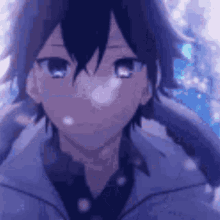 a close up of a boy 's face with snow falling on it .