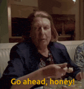 a woman sitting at a table with the words go ahead honey