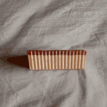 a piece of chocolate that looks like a comb sits on a white cloth