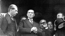 a group of men in suits and ties are standing next to each other .