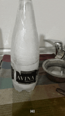 a bottle of avina frizzante water sits on a table