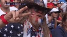 a man wearing a cowboy hat is giving a peace sign while watching a game between the usa and the netherlands