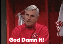 a man in a red shirt is sitting in a locker room with a basketball jersey hanging on a hanger .