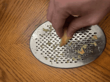 a person grating a lemon on a grater on a wooden table