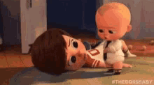 a cartoon baby is laying on the floor next to a baby doll .