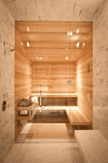 a wooden sauna with a glass door and a shower