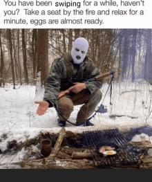 a man in a ski mask is squatting in the snow with a rifle