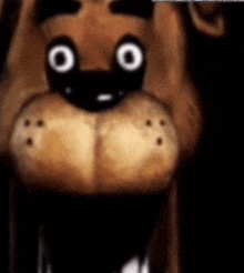 a close up of a teddy bear 's face with big white eyes and teeth .