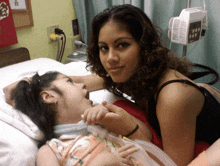 a girl laying in a hospital bed with an oxygen mask on her face