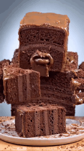 a stack of chocolate cakes on a plate with one slice missing