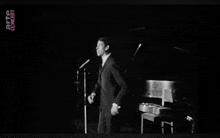 a black and white photo of a man singing into a microphone