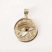 a gold pendant with an eye on it