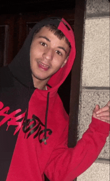 a man wearing a red and black hoodie that says supreme