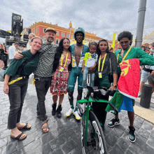 a group of people posing for a picture with a man in a green shirt that says cube on it