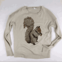 a sweater with a squirrel on it has a tag that says ' abercrombie & fitch ' on it