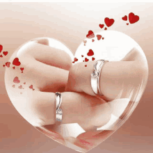 a couple holding hands with rings on their fingers in a heart