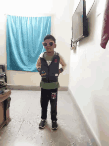 a young boy wearing sunglasses and a vest with the number 7 on the side
