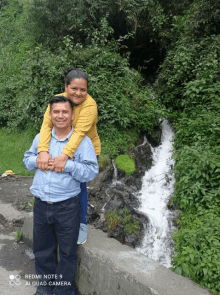 a man and woman posing for a picture with a redmi note 9