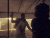 a man is standing in a dark room with a woman standing behind him