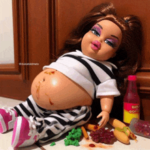 a doll is laying on the floor with a bottle of barbeque sauce in the background