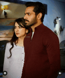 a man and a woman are standing next to each other and the man is wearing a maroon shirt