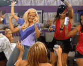 a group of women are dancing in a room and one woman is taking a picture