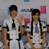a group of girls are standing in front of a wall with ana written on it