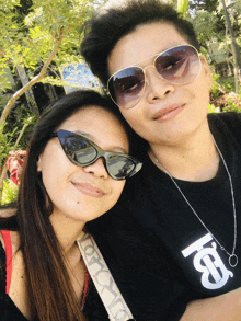 a man wearing sunglasses and a woman wearing sunglasses are posing for a photo