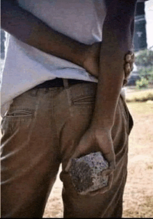 a man is holding a large rock in his hands
