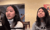 two young women are sitting next to each other in a living room making funny faces .