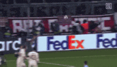 a soccer field with a fedex ad in the background