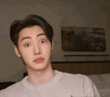 a young man with a surprised look on his face wearing a white shirt
