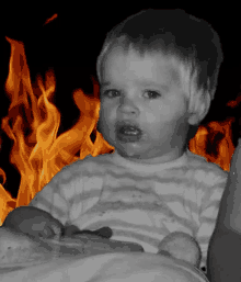 a baby in a striped shirt is in front of a fire background