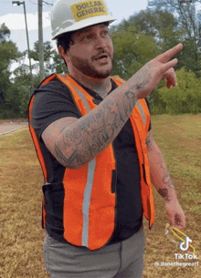 a man wearing an orange vest and a hard hat with dollar general on it