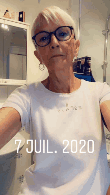 a woman wearing glasses and a white shirt has the date 7 jul 2020 on her shirt