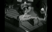 a black and white photo of a living room with a woman dancing