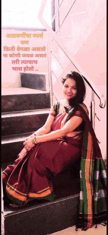 a woman in a red and green saree sits on stairs