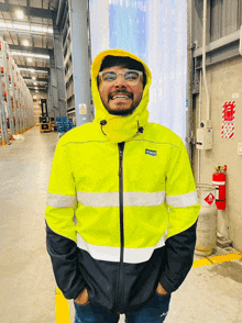 a man wearing a yellow and black jacket with a hood that says inco on it