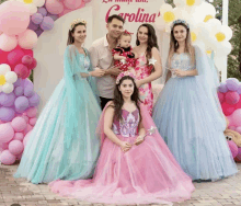 a group of people posing for a picture in front of a wall that says carolina