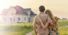 a man and a woman are looking at a house