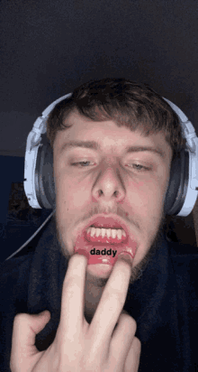 a man wearing headphones has the word daddy written on his lip