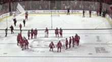 a group of hockey players standing on a ice rink with a banner that says uc on it