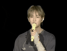 a man holding a yellow microphone that says return